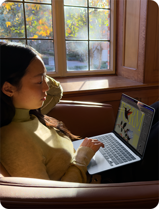 Osoba siedząca na krześle i korzystająca z MacBooka Air